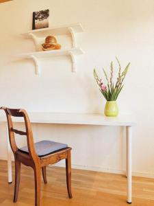 stół z krzesłem i wazon z kwiatami w obiekcie Haus Bergblick w mieście Rettenberg