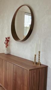 a mirror on top of a wooden dresser with two candles at Atrium Apartments Aachen in Aachen