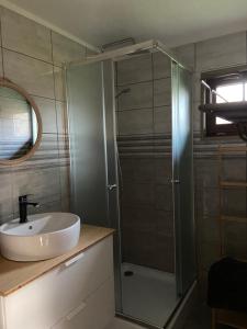 W łazience znajduje się umywalka i przeszklony prysznic. w obiekcie Faház a kertben Apartman 2 w mieście Balatonkenese