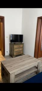 een houten tafel met een tv op een dressoir bij Apartment OB in Oberhausen