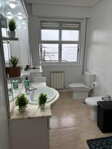 a bathroom with a sink and a toilet and a mirror at Chalet Galicia Landin in Redondela