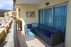 un sofá azul sentado en el balcón de un apartamento en Ocean View Palapa, en Jan Thiel