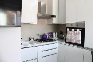 a white kitchen with a stove and a sink at Casa Franca in Maracalagonis