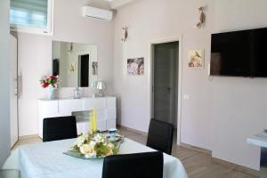 a dining room with a table and chairs and a television at Casa Franca in Maracalagonis