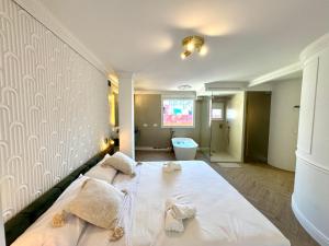 una camera da letto con un grande letto bianco con asciugamani sopra di Luxury Cathedral Views in Sevilla a Siviglia