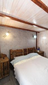 a bedroom with a white bed with a wooden headboard at Котедж "Красний Краєвид" in Yaremche