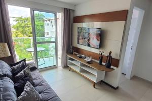 a living room with a couch and a table and a window at Condomínio Porto de Soleil in Porto De Galinhas