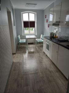 - une cuisine avec une table et des chaises dans la chambre dans l'établissement Twój Dom, à Mrągowo