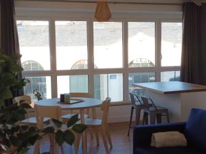 ein Wohnzimmer mit einem Tisch und Stühlen vor einem Fenster in der Unterkunft citybreak des balcons d'Ancenis in Ancenis