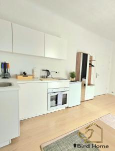 an empty kitchen with white cabinets and a sink at Bird Home Room 11 in Klagenfurt