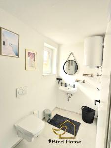 a white bathroom with a sink and a toilet at Bird Home Room 11 in Klagenfurt