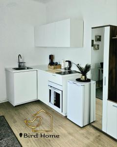a kitchen with white cabinets and a stove top oven at Bird Home Room 11 in Klagenfurt