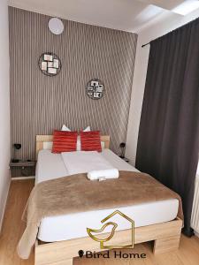 a bedroom with a large bed with red pillows at Bird Home Room 11 in Klagenfurt