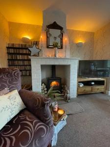 a living room with a couch and a fireplace at Mulberry Annexe in Felixstowe