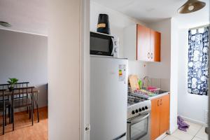 uma cozinha com um frigorífico e um fogão forno superior em Lindisimo departamento cerca del Parque O'higgins em Santiago