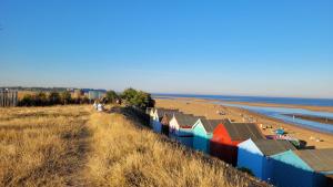 Blick auf einen Strand mit bunten Strandhütten in der Unterkunft Mulberry Annexe in Felixstowe