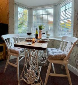 een eettafel met 2 stoelen en wijnglazen bij Mulberry Annexe in Felixstowe
