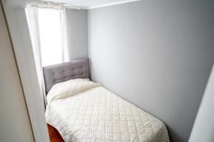 uma pequena cama num canto de um quarto com uma janela em Lindisimo departamento cerca del Parque O'higgins em Santiago