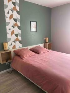ein Schlafzimmer mit einem großen Bett mit rosa Bettwäsche in der Unterkunft Maison tout confort in Cambo-les-Bains