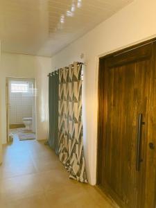 a bathroom with a shower and a wooden door at Avery's Perch in Livingstone
