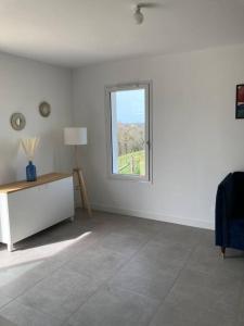 Dieses weiße Zimmer verfügt über ein Fenster und einen Tisch. in der Unterkunft Maison tout confort in Cambo-les-Bains