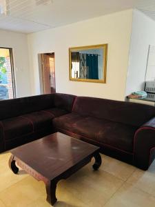 Sala de estar con sofá marrón y mesa de centro en Avery's Perch en Livingstone