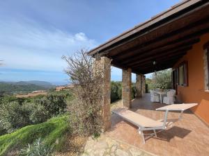 a patio with a table and a bench on a house at Villa Rocce Rosse in Costa Paradiso