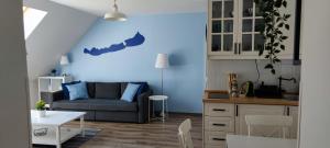 uma cozinha e uma sala de estar com uma parede azul em FreshGarden Family Resort em Siófok