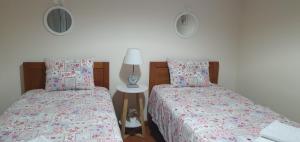 two beds sitting next to each other in a bedroom at Casa dos Imos in Alvados