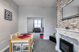 a dining room with a table and a fireplace at Colston 5 Bedroom House Newcastle in Newcastle upon Tyne