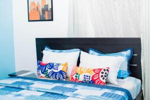 Una cama con un montón de almohadas. en 3Tee Serviced Apartment Abeokuta en Abeokuta