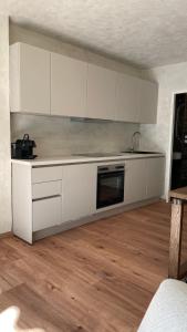 uma cozinha com armários brancos e piso em madeira em Atrium Apartments Aachen em Aachen
