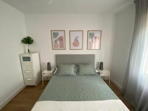een slaapkamer met een bed en drie foto's aan de muur bij APARTAMENTO RECONQUISTA in Toledo