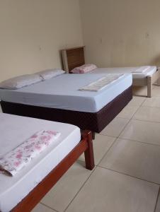 two beds in a room with at Pousada Ebenezer in Andradina