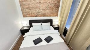 a bedroom with a bed with two pillows on it at Elegant Central park Apartment in Daugavpils