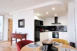 a kitchen and dining room with a table and chairs at Le Joyau Des Parcs classé 4 étoiles appartement central au calme avec terrasse in Vichy