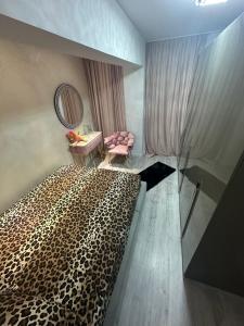 a bedroom with a leopard print bed and a chair at Apartament Chloe in Tulcea