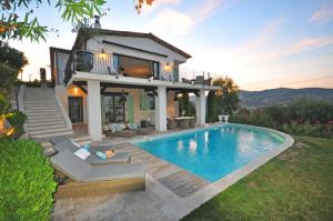a villa with a swimming pool in front of a house at Riviera Living in Mandelieu-la-Napoule