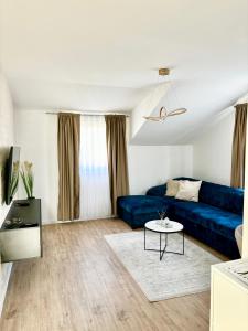 sala de estar con sofá azul y mesa en Apartman Star #2 en Vinkovci