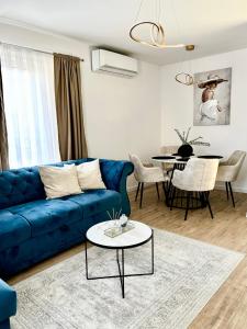 uma sala de estar com um sofá azul e uma mesa em Apartman Star #2 em Vinkovci