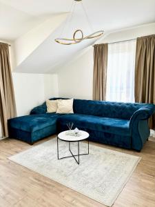 um sofá azul numa sala de estar com uma mesa em Apartman Star #2 em Vinkovci