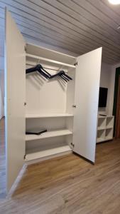 vestidor con paredes blancas y suelo de madera en Messe- und Ferienwohnung am Ponyhof Nürnberg en Núremberg