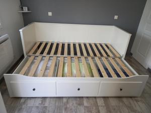 a white bed in a room with wooden floors at Studio "l'aube du Perche" in La Mancelière