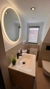 3 Zimmer Apartment mit Parkplatz - Sleepomat في أشافنبورغ: حمام مع حوض أبيض ومرآة