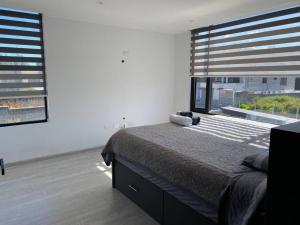 a bedroom with a bed and a large window at Hermosa casa en la Armenia in Quito