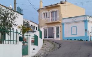 a house with a fence in front of a street at Studio Rocha Carvoeiro- Open Space in Carvoeiro
