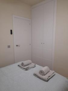 a white room with two towels on a bed at Apartamento Playa Paseo Marítimo Almería in Almería