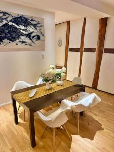 ein Esszimmer mit einem Tisch und 2 weißen Stühlen in der Unterkunft Wohnung in Weilburg am Schloss in Weilburg
