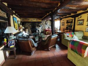 a living room with leather furniture and a stone wall at Casa Simón in Cervera de Pisuerga