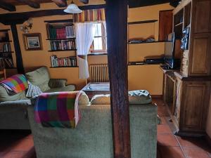 a living room with a couch and a tv at Casa Simón in Cervera de Pisuerga